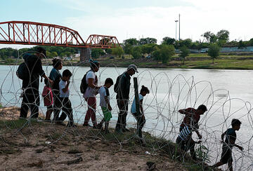 People crossing through wire at a river